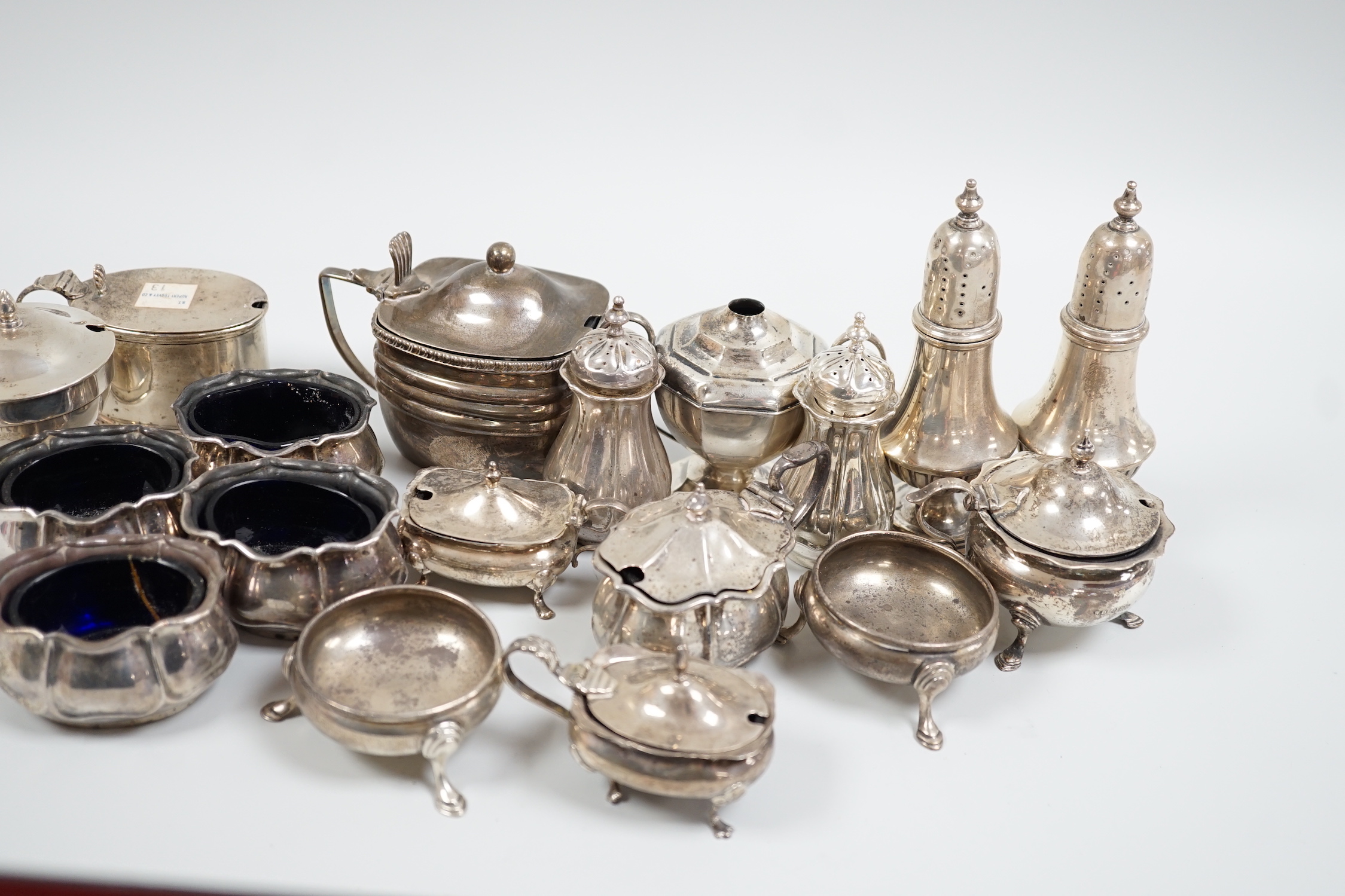 An Edwardian seven piece silver condiment set, Atkin Bros. Sheffield, 1903/4 and eleven other silver condiments including a pair of pepperettes.